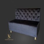Čalouněná pohovka s Chesterfield prošíváním v černém veluru a zlatými nožkami. Kompaktní pohovka do kosmetického salonu, recepce nebo čekárny.